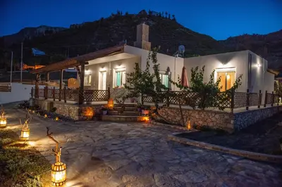 a house with lights in front of it at night at Ktima Argyrou Stegna in Archangelos