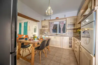 a kitchen with a wooden table and chairs and a dining room at Ktima Argyrou Stegna in Archangelos