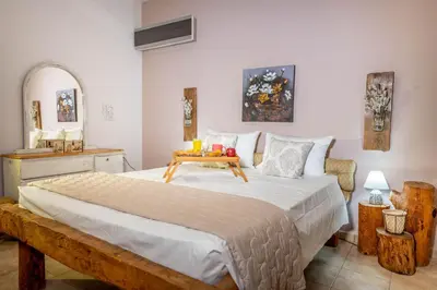 a bedroom with a large bed with a table on it at Ktima Argyrou Stegna in Archangelos