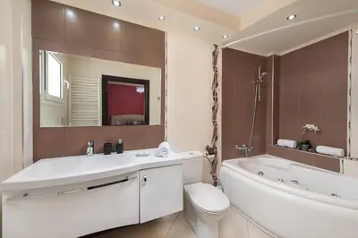 a bathroom with a sink and a tub and a toilet at Marble Pool Villa in Pastida