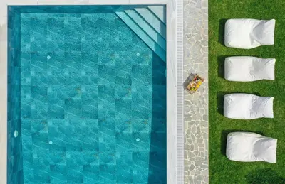 an overhead view of a swimming pool with white pillows at Marble Pool Villa in Pastida