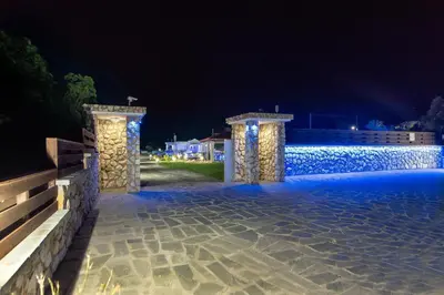 a patio at night with two pillars and a fence at Marble Pool Villa in Pastida