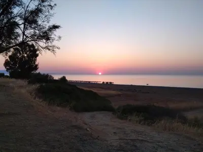 a sunset on a beach with the sun setting at Endless BLUE Lahania in Lachania