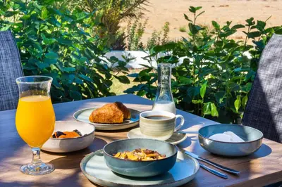 a table with plates of food and a glass of orange juice at Nirvana Beach Hotel in Theologos