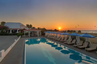 a pool with chairs and umbrellas at a resort at Nirvana Beach Hotel in Theologos