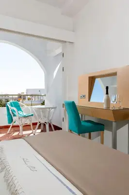 a bedroom with a bed and a desk and chairs at Kolymbia Sun in Kolimbia