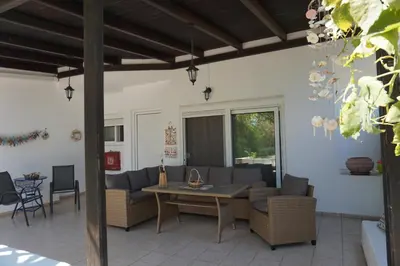 a patio with a table and chairs and a couch at Nicholas Waves Beach Studios in Lardos