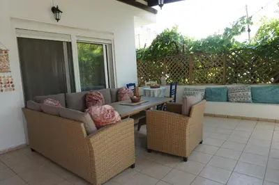 a patio with couches and a table and chairs at Nicholas Waves Beach Studios in Lardos