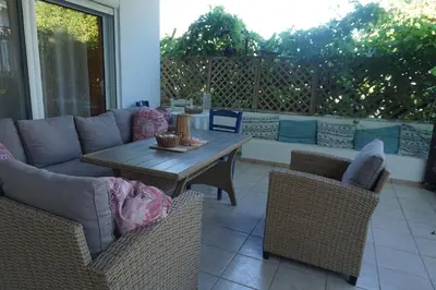 a patio with a couch and tables and chairs at Nicholas Waves Beach Studios in Lardos