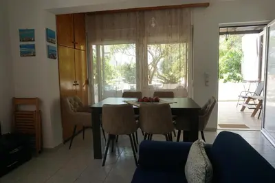 a living room with a dining room table and chairs at Nicholas Waves Beach Studios in Lardos