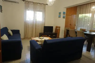 a living room with two blue couches and a table at Nicholas Waves Beach Studios in Lardos