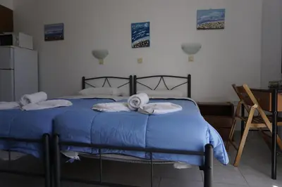 a bedroom with a blue bed with towels on it at Nicholas Waves Beach Studios in Lardos