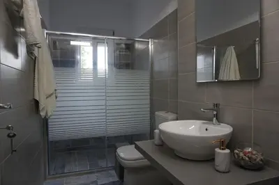 a bathroom with a toilet and a sink and a shower at Nicholas Waves Beach Studios in Lardos