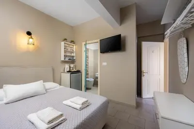 a bedroom with a bed with two towels on it at Maravelia's Rooms in Symi