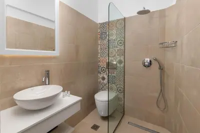 a bathroom with a toilet and a sink and a shower at Maravelia's Rooms in Symi