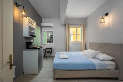 a bedroom with a bed and a kitchen in it at Maravelia's Rooms in Symi