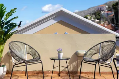 two chairs and a table on a balcony at Maravelia's Rooms in Symi