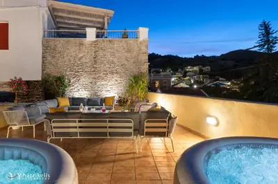 a patio with two hot tubs on a balcony at Maravelia's Rooms in Symi
