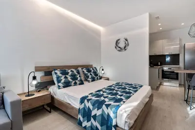 a bedroom with a bed and a desk and a kitchen at George Beach Studios in Pefki Rhodes