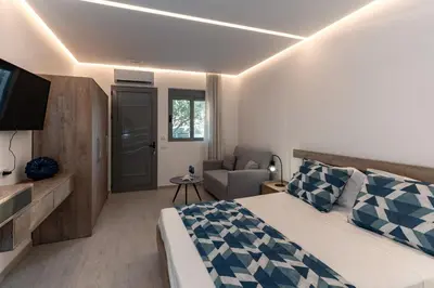 a bedroom with a bed and a couch and a television at George Beach Studios in Pefki Rhodes