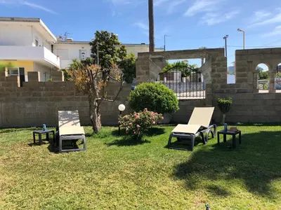 a yard with two chairs and a table and a tree at Jimmy’s Garden in Faliraki