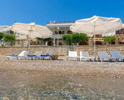 a group of chairs and umbrellas on a beach at Haraki Sea View Luxury House in Rhodes Town