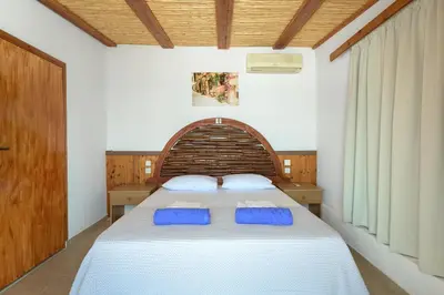 a bedroom with a bed with two blue pillows on it at Haraki Sea View Luxury House in Rhodes Town
