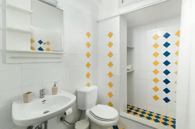 a white bathroom with a toilet and a sink at Maximos Sea & The City in Rhodes Town