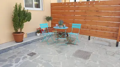 a patio with a table and chairs and a fence at Maximos Sea & The City in Rhodes Town