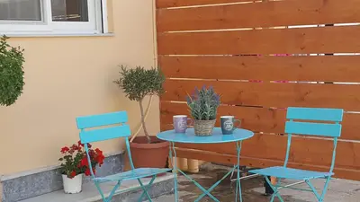 two blue chairs and a table with two mugs on it at Maximos Sea & The City in Rhodes Town