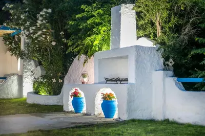 two flowers in blue vases on a wall with a bench at Faliraki Blue Villas in Faliraki