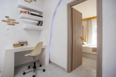 a room with a desk and a chair and a door at Faliraki Blue Villas in Faliraki