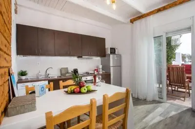 a kitchen with a table with a bowl of fruit on it at Faliraki Blue Villas in Faliraki