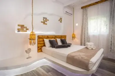 a white bedroom with a large bed and a window at Faliraki Blue Villas in Faliraki