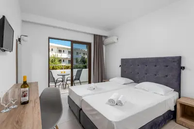 a hotel room with a bed and a balcony at Afandou Blu in Afantou