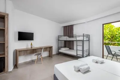 a bedroom with two beds and a tv and a desk at Afandou Blu in Afantou