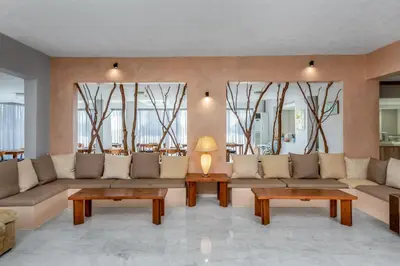 a living room with couches and tables and windows at Afandou Blu in Afantou