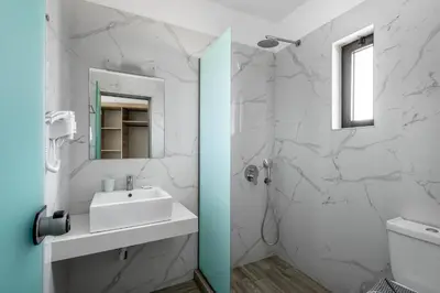 a white bathroom with a sink and a mirror at Afandou Blu in Afantou