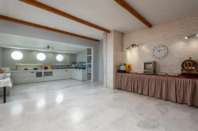 a large kitchen with a clock on a brick wall at Afandou Blu in Afantou