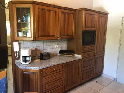 a kitchen with wooden cabinets and a counter with a microwave at Villa Sophia in Soroni