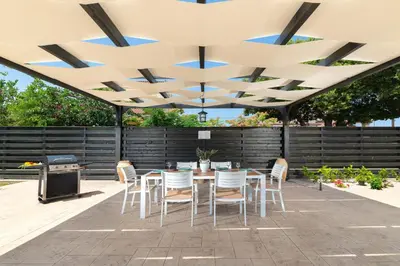 a patio with a table and chairs under awning at Villa Sophia in Soroni