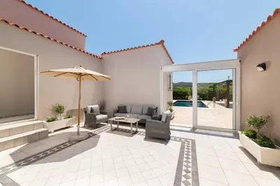 a patio with a table and an umbrella and a pool at Villa Sophia in Soroni