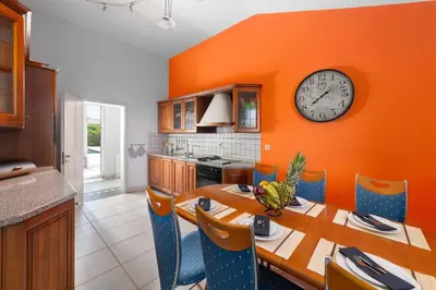 a kitchen with a table and a clock on the wall at Villa Sophia in Soroni