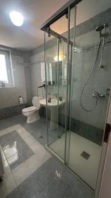 a bathroom with a glass shower and a toilet at Villa Sophia in Soroni