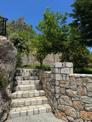 a stone retaining wall with a set of stairs at Villa Rose in Archangelos