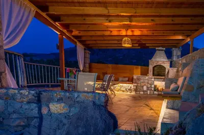 an outdoor patio with a fireplace and a wooden ceiling at Villa Rose in Archangelos