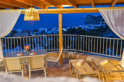 a table and chairs on a balcony with a view at Villa Rose in Archangelos