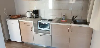 a small kitchen with a microwave and a sink at Ria's Deluxe Apartments in Faliraki