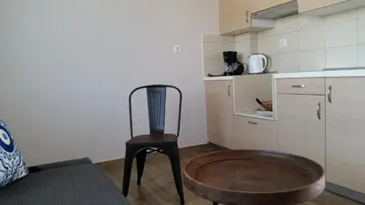 a kitchen with a wooden chair in a room at Ria's Deluxe Apartments in Faliraki