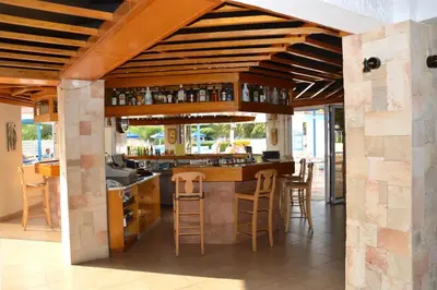 a kitchen with a bar with stools around it at Muses Hotel in Faliraki